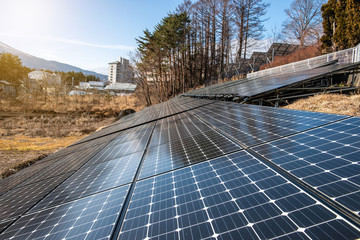 Solar panels (solar cell) in solar farm with blue sky and sun lighting