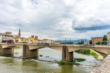 Fototapeta premium Italy,Florence, a train crossing a bridge over a river