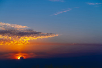 Sunny shine on clouds. Wonderful vivid dawn. Beautiful calm orange sunset. Scenic surreal sunrise. Amazing blue cloudy sky. Picturesque sundown. Atmospheric cloudscape. Circle of sun above horizon.
