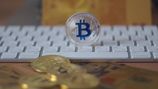 Silver bitcoin cymbol on keyboard. Selective focus.