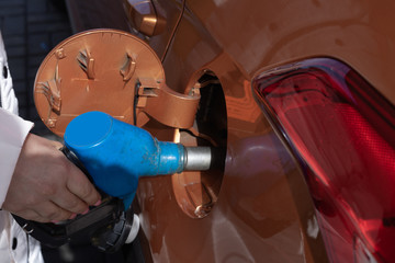 Hand refilling the car with fuel at the refuel station