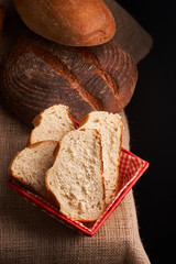 Top view of sliced wholegrain bread on dark ructic wooden background closeup