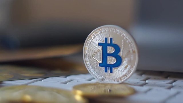 Silver bitcoin cymbol on keyboard. Selective focus.