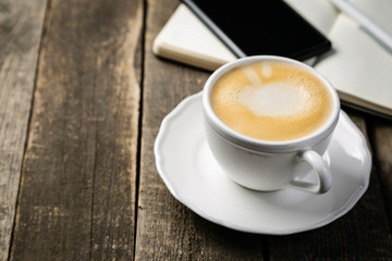 BUsiness morning concept - coffee, notebook, phone, rustic wood background