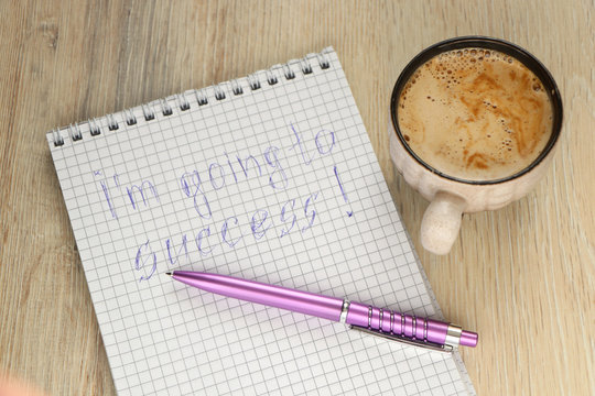 mug with coffee and a pen on a notebook with the inscription I'm going to success