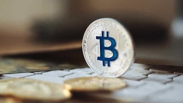 Silver bitcoin cymbol on keyboard. Selective focus.