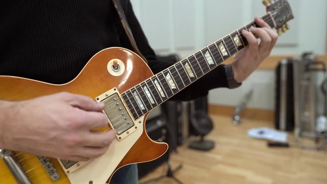 Electric guitar strumming in recording studio.