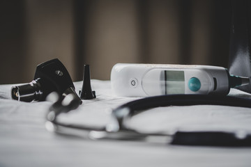 A doctors bag at a clinic - showing stethoscope, otoscope and thermometer.