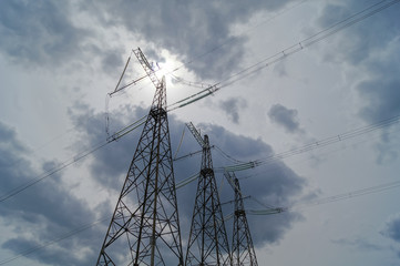 Power transmission towers on a background of cloudy sky with gray clouds