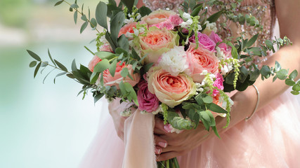 Beautiful bridal bouquet in hands of the bride. Wedding bouquet of peach roses by David Austin, ...