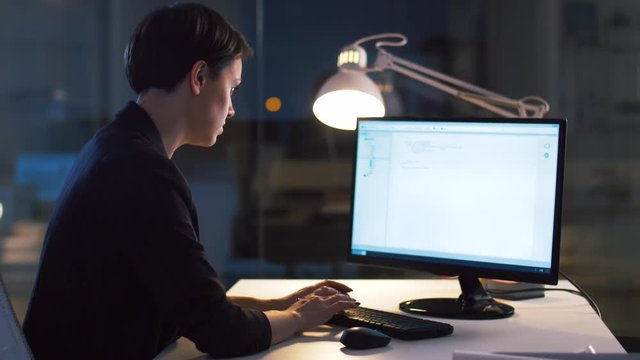 business, deadline and technology concept - businesswoman with computer working at dark night office