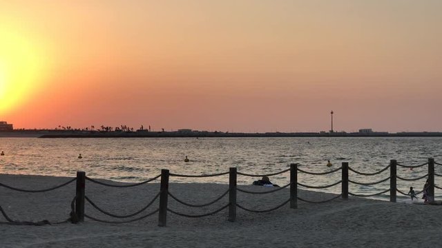 Sunset in Mercato Beach in  Dubai, United Arab Emirates. Families with children in a public beach.