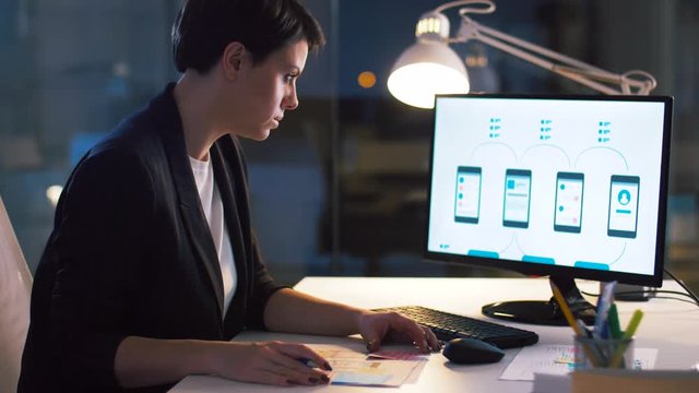 business, technology and people concept - ui designer with smartphone templates on computer screen working on user interface design at dark night office