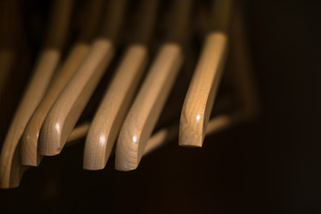 Perchas de madera color roble claro sobre fondo negro dentro de un armario en un hotel en Oporto...