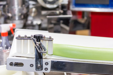 Obraz premium close up roll dough material for chinese or asian food steamed stuffed buns on automatic belt conveyor of food making machine in production line for high technology industrial manufacturing