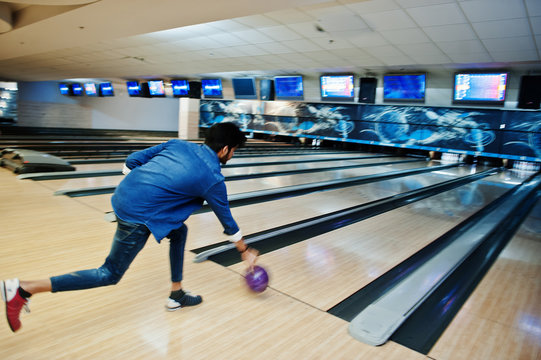 Blur Photo Of Back South Asian Man Throws Bowling Ball On Motion At Alley.