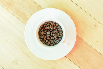 Coffee bean in the cup on wood plate