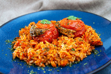 stuffed tomatoes with rice on a white plate