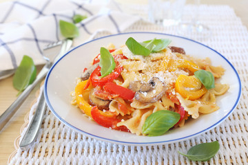 Italian food. Farfalle pasta with mushrooms and sweet belle pepper, parmesan cheese dressing