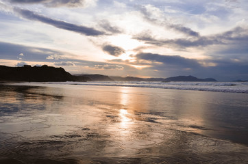 Obraz premium Beautiful sunset on the beach of sopelana with warm tones and an incredible sky. vizcaya, basque country, spain