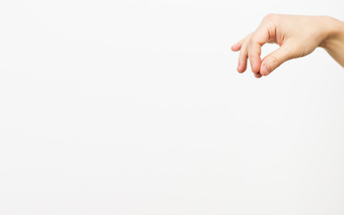 Hand of a caucasian male to hold some tiny or thin object, isolated on white - selective focus