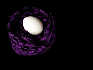 The egg lies in a scarf. Easter. Eggs in colored scarves.
