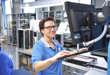 Frau in einer Fabrik bedient anlage zur Produktion von Elektronik // Woman in a factory operates plant for the production of electronics