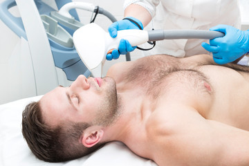 Man on the procedure of laser hair removal in the beauty salon