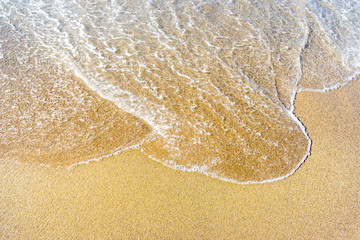 Soft wave of blue sea on sandy beach.