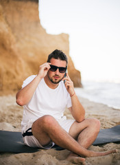 young woman talking with mobile phone on the beach