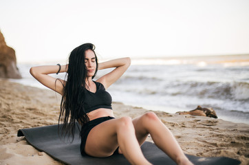 Fototapeta na wymiar sport and lifestyle concept - woman doing sports by sea. Beautiful teenage sport woman doing stretching exercise on sand beach