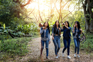 Fototapeta premium Trekking holiday concept.Four women are trekking in the mountains with backpack,tent,hiking equipment.