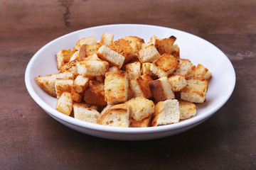 Delicious crispy croutons, crumbs of bread in white plate. ready for cooking.