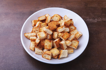 Delicious crispy croutons, crumbs of bread in white plate. ready for cooking.