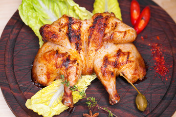 Roast chicken and leaf lettuce on a wooden board