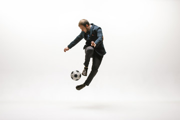 Naklejka na ściany i meble Businessman with football ball in office. Soccer freestyle. Concept of balance and agility in business. Manager perfoming tricks isolated on white studio background.