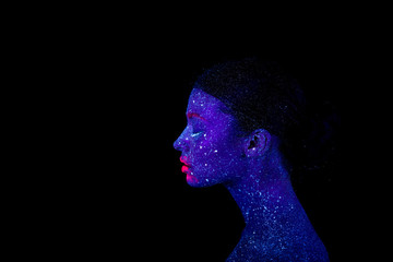Profile of an alien woman with blue skin and pink lips, ultraviolet makeup on a black background.