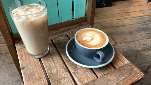 Pretty latte coffee with heart design. Chai latte, mocha, cappuccino, macchiato and caramel latte with art design. Ice coffee and latte in rustic coffee shop.