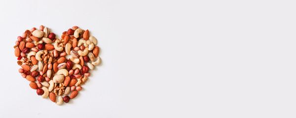 Mixed nuts forming a heart shape isolated on white background. Top view or flat lay