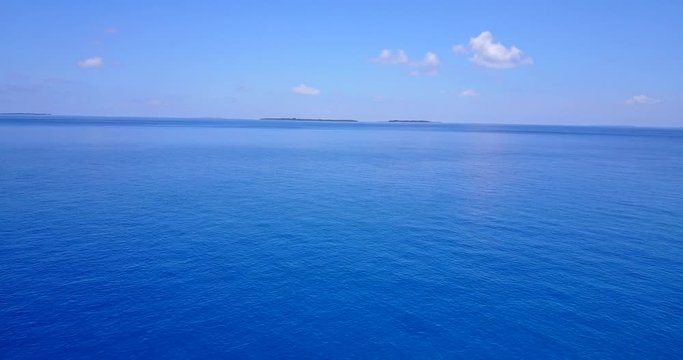 Perfect blue ocean, flying over the pristine Maldives sea on gorgeous day, 4k