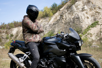Obraz premium Journey to a motorcycle through a career. The motorcyclist wearing a helmet on a motorcycle