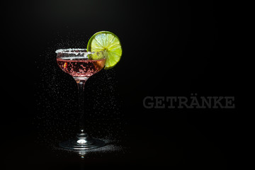 Kohlensäurehaltiges Getränk mit Kohlensäure im Glas mit Limette vor schwarzem Hintergrund als Getränkekarten-Couver
