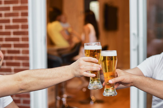Cropped image Hands of a group of voiced glasses of beer, parties and celebrations. beer glasses at home on the terrace of the house