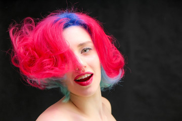 High fashion model woman with multi-colored hair posing in studio, portrait of beautiful sexy girl with a fashionable makeup and manicure.