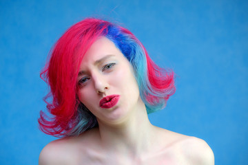 High fashion model woman with multi-colored hair posing in the studio, portrait of a beautiful sexy girl with a fashionable makeup and manicure.