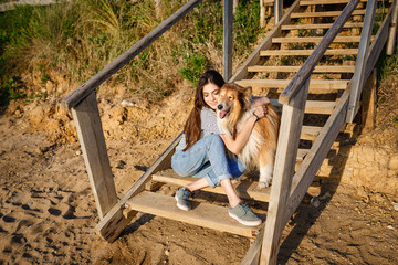 young beautiful woman walking with collie dog.