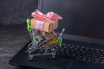 Daily purchases and gifts in the shopping cart on the laptop keyboard. Shopping in online stores