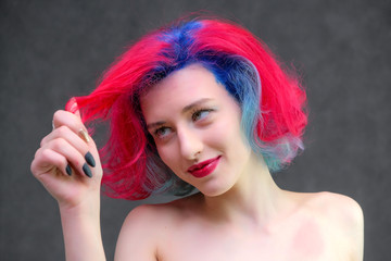 High fashion model woman with multi-colored hair posing in the studio, portrait of a beautiful sexy girl with a fashionable makeup.