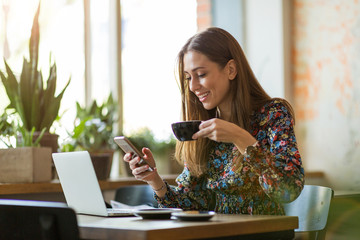 Young woman with laptop in cafe