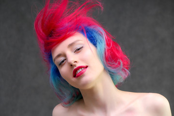 High fashion model woman with multi-colored hair posing in the studio, portrait of a beautiful sexy girl with a fashionable makeup.